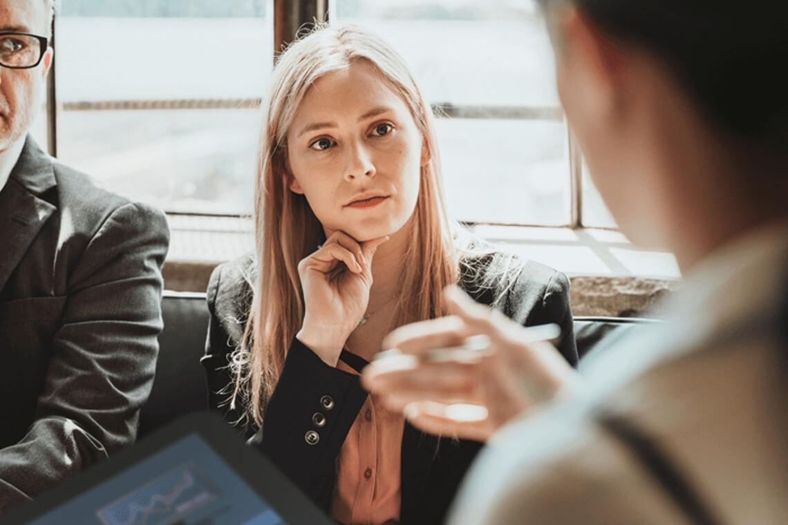Conversación entre dos compañeros con una tablet en la mano 